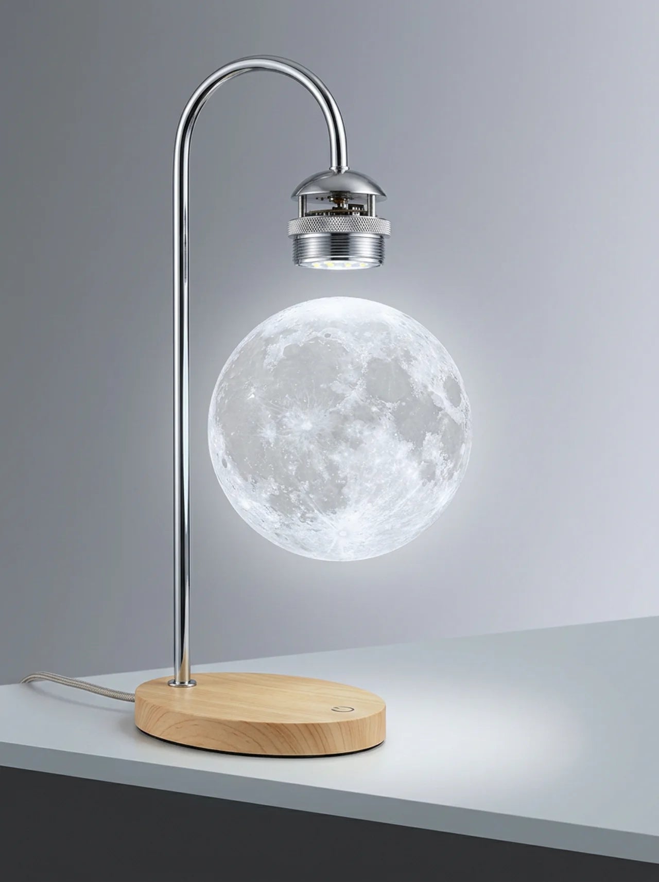 Table lamp with a moon-shaped light on a wooden base against a gray background
