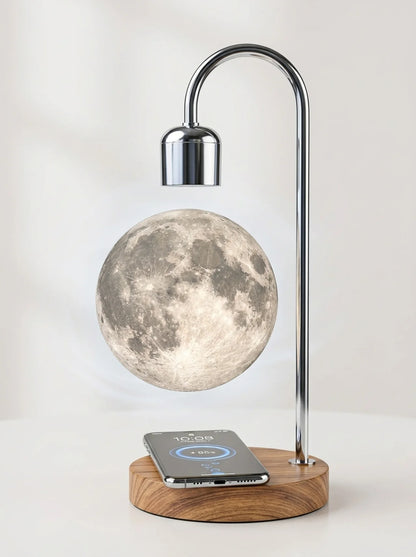 Moon lamp on a wooden base with a smartphone charging on it, against a white background